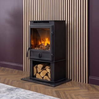 Black freestanding stove with fire burning inside, surrounded by wooden logs against a striped wall.