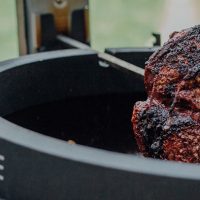 Slow cooking meat over BBQ